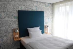 a bedroom with a bed and a blue wall at Grimm's Potsdamer Platz in Berlin