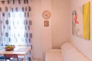 een woonkamer met een bank en een klok aan de muur bij Orsiida Sea view apartment in Agria