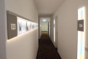 a hallway of a hotel with paintings on the walls at Grimm's Potsdamer Platz in Berlin