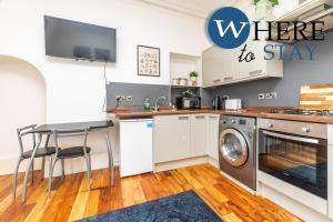 uma cozinha com uma máquina de lavar e secar roupa e uma mesa em Lovely Aberdeen Apartment, Free Parking, River Side em Aberdeen