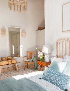 1 dormitorio con 1 cama, mesa y sillas en Cuadra rehabilitada, piscina climatizada, Comillas, en Lamadrid