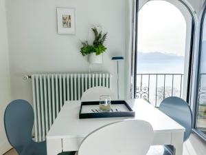 un tavolo bianco con sedie e vista su un balcone di Room with 360° view overlooking Lake Geneva and Alps a Puidoux