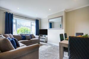 a living room with a couch and a tv at Potter's Escape-walking distance from The Studios! in Abbots Langley