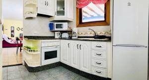 a kitchen with white cabinets and a window at Villa Descansa with private pool, sea view, Sat-tv free Wifi in Playa Blanca