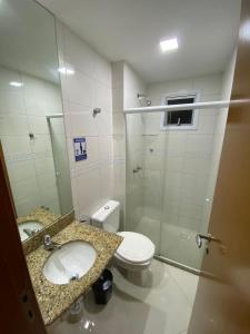 a bathroom with a toilet and a sink and a shower at Apartamento de frente para o mar Praia do Morro Guarapari in Guarapari