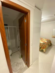 a bathroom with a door leading to a bedroom at Apartamento de frente para o mar Praia do Morro Guarapari in Guarapari