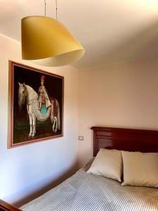 a bedroom with a painting of a man riding a horse at Donna Vittori - Borgo Agricolo in Paliano
