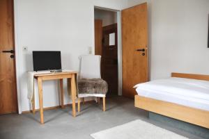 a bedroom with a bed and a desk with a computer at Schildwirtschaft Zum Rothen Ochsen in Laupheim