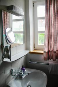baño con lavabo, espejo y ventana en Schildwirtschaft Zum Rothen Ochsen, en Laupheim