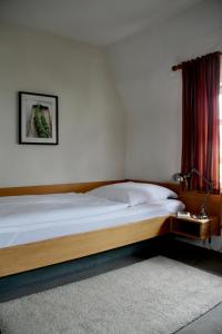 1 dormitorio con cama de madera y ventana en Schildwirtschaft Zum Rothen Ochsen, en Laupheim
