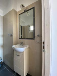 a bathroom with a sink and a mirror at andros prive suites in Kipri