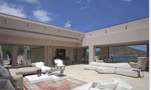 a living room with white furniture and a view of the water at MEDOUSA VILLA in Porto Rafti