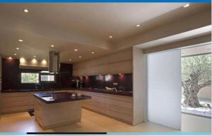 a large kitchen with a counter and a window at MEDOUSA VILLA in Porto Rafti