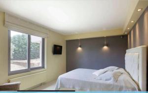 a bedroom with a bed and a window at MEDOUSA VILLA in Porto Rafti