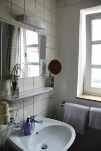 Baño blanco con lavabo y espejo en Schildwirtschaft Zum Rothen Ochsen, en Laupheim