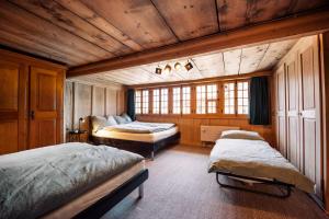 1 dormitorio con 2 camas en una habitación con techos de madera en Ferienhaus Chalet Oberdorf, en Brienz