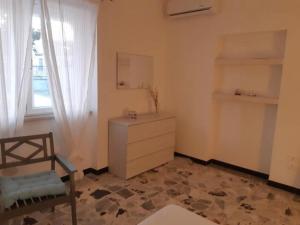 um quarto com uma cómoda, uma janela e uma cadeira em Appartamentino2 Collina Costa Dei Trabocchi em Villalfonsina