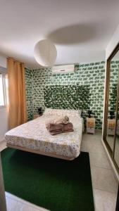 1 dormitorio con 1 cama con pared verde en Estancia de Ensueño y Relax Parking Gratuito en Granada