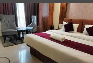 um quarto de hotel com uma cama grande e uma cadeira em HOTEL DAISY em Guwahati