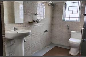 a bathroom with a sink and a toilet and a window at HOTEL DAISY in Guwahati +11 photos