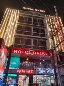 グワーハーティーにあるHOTEL DAISYのホテルの建物の前にネオンの看板が出ています。