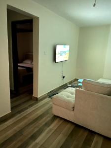 a living room with a couch and a flat screen tv at Meelmak apartment in Nairobi