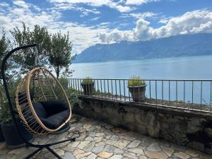 a chair sitting on a wall with a view of the water at Panoramic Room in the vineyard,stunning views of lake and Alps in Puidoux