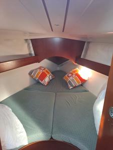 1 dormitorio pequeño con 2 almohadas en un barco en Le voilier du soleil, en Sainte-Marie-la-Mer