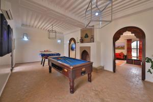 a room with a pool table and a fireplace at DOMAINE DU DOUAR in Marrakech