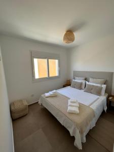 ein weißes Schlafzimmer mit einem großen Bett mit Handtüchern darauf in der Unterkunft Apartment in Lo Pagán - San Pedro Del Pinatar- Rooftop - Swimming Pool - Beach 50m away ! in San Javier + 23 Fotos