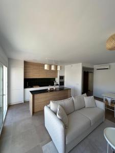 ein Wohnzimmer mit Couch und Küche in der Unterkunft Apartment in Lo Pagán - San Pedro Del Pinatar- Rooftop - Swimming Pool - Beach 50m away ! in San Javier