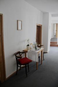 a dining room with a table and a red chair at Schildwirtschaft Zum Rothen Ochsen in Laupheim