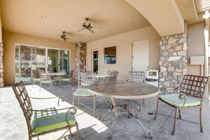 un patio con mesa, sillas y pared de piedra. en Coral Ridge Retreat, en Washington