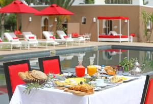 a table with food on it next to a pool at DOMAINE DU DOUAR in Marrakech