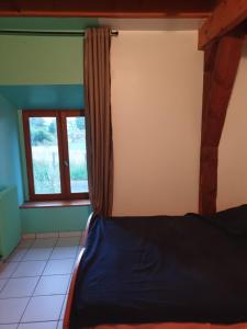 1 dormitorio con cama y ventana en Chambre d'hôtes Aubrac Nasbinals a75 