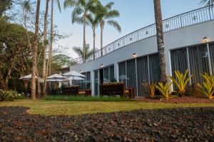 a building with chairs and umbrellas and palm trees at Villa Hotel in Rio Piracicaba