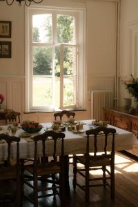 ein Esszimmer mit einem Tisch und einem Fenster in der Unterkunft Petit Chateau Vercourt in Vercourt