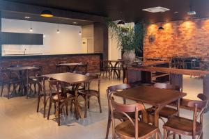 a restaurant with tables and chairs and a brick wall at Villa Hotel in Rio Piracicaba