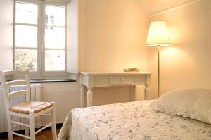 a bedroom with a bed and a desk and a window at La Casa dei Nonni Castelbianco in Castelbianco