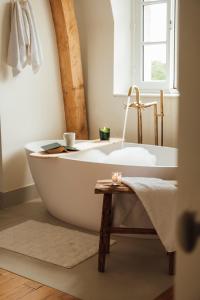 a bath tub in a bathroom with a window at Petit Chateau Vercourt in Vercourt