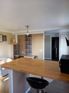 een keuken en een woonkamer met een houten tafel en stoelen bij La Grelauderie 4 in Saintes