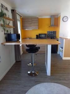 een keuken met een aanrecht met 2 barkrukken bij La Grelauderie 4 in Saintes