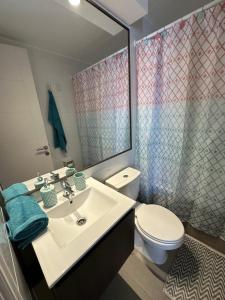 a bathroom with a sink and a toilet and a mirror at Departamento 3D2B Condominio Altos de Huayquique in Iquique +13 photos