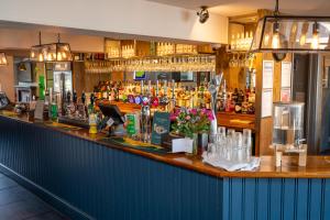 a bar with a lot of bottles of alcohol at St Leonards Hotel by Greene King Inns in Saint Leonards