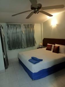a bedroom with a large bed with a ceiling fan at Kingfisher House and Bar in Pattaya South