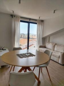 een woonkamer met een tafel en stoelen en een bank bij Mini Condos® 28DL - 1 bed condo, 2 min to the sea in Tivat