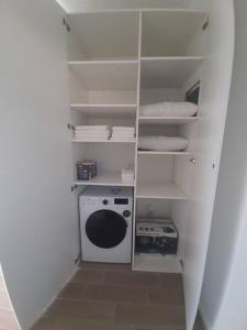 een witte kast met een wasmachine bij Mini Condos® 28DL - 1 bed condo, 2 min to the sea in Tivat