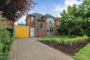 ein Backsteinhaus mit gelber Tür und Einfahrt in der Unterkunft Elegant 3-Bed Home, West Bridgford & Large Garden in Nottingham