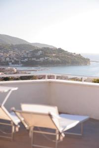 Duas cadeiras numa varanda com vista para o oceano em Orizzonte Mare Panoramic Rooms em Agropoli