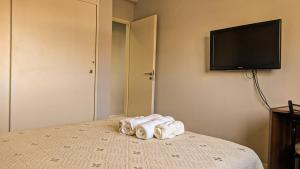a bedroom with a bed with towels and a flat screen tv at BELGRANO 124 - CORRIENTES in Corrientes